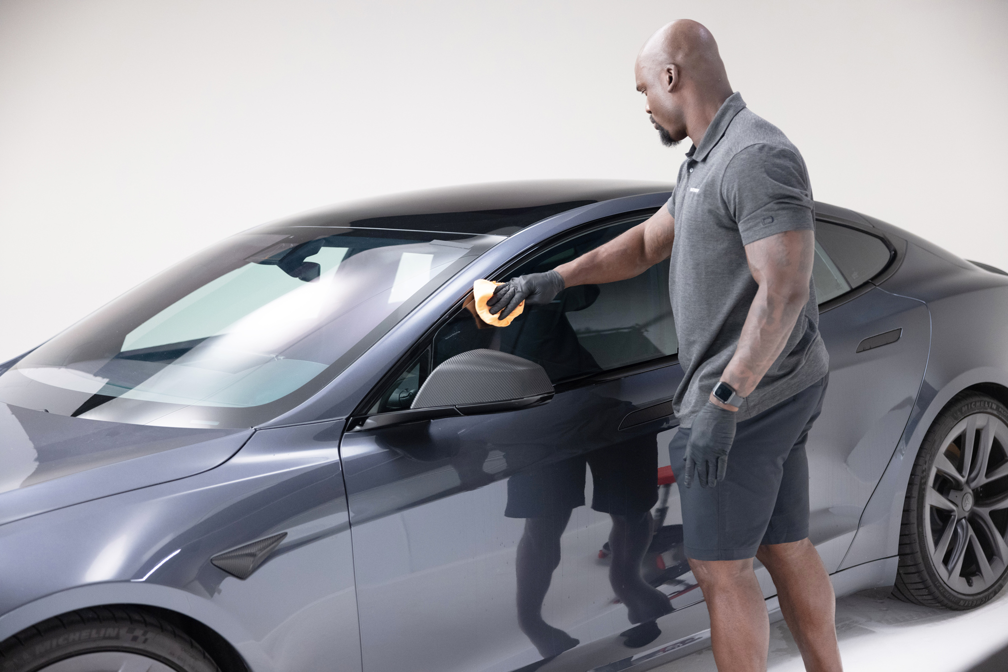 Automotive Window Tint installer applying film to the driver's side window 